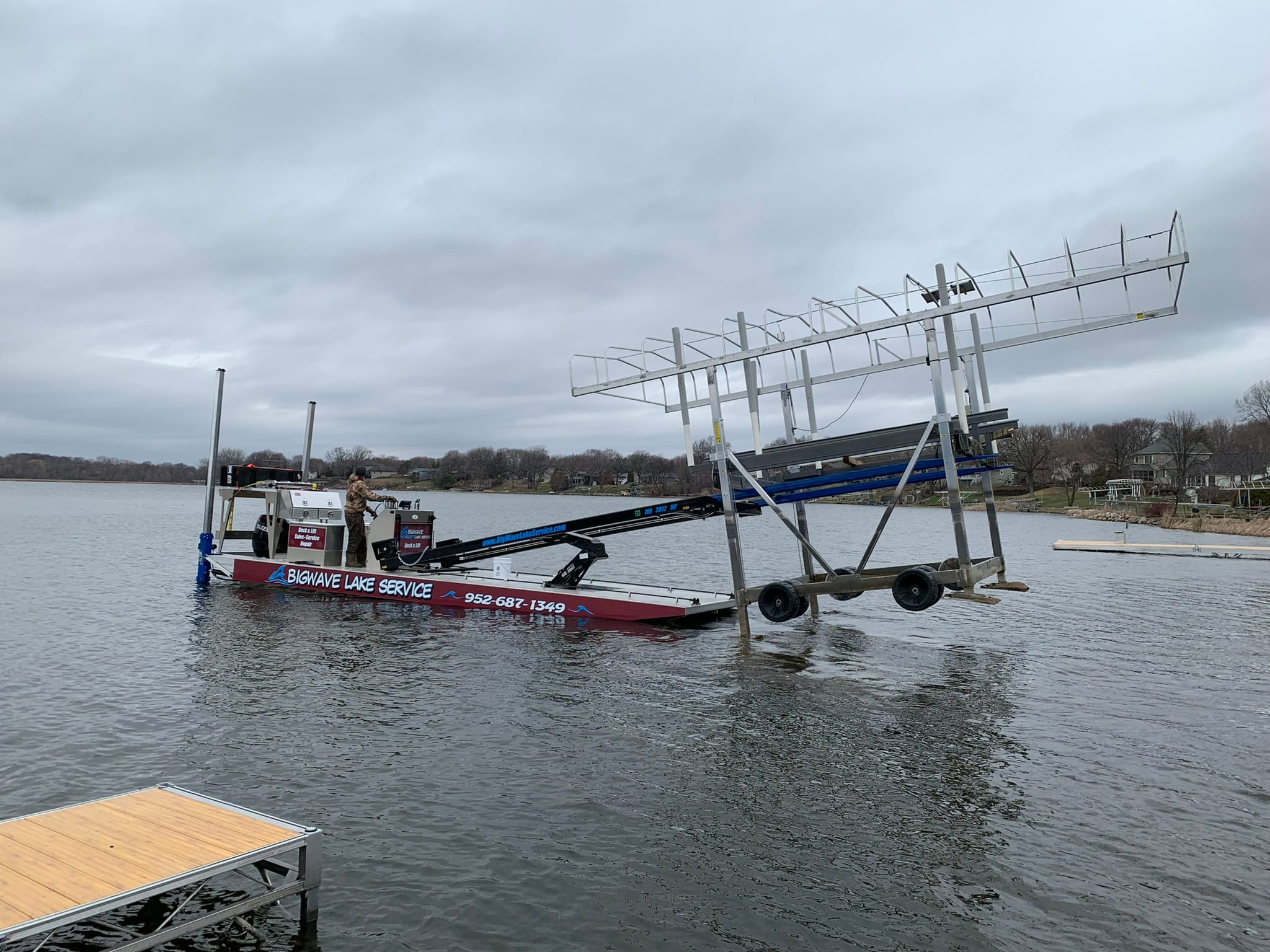 BigWave barge carrying a boat lift frame across the water toward a dock