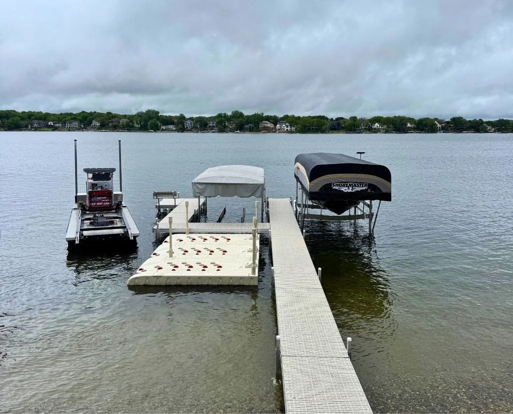 New dock with two canopied boat lifts and a jet ski port on Lake Minnetonka, with the BigWave barge tied up beside it