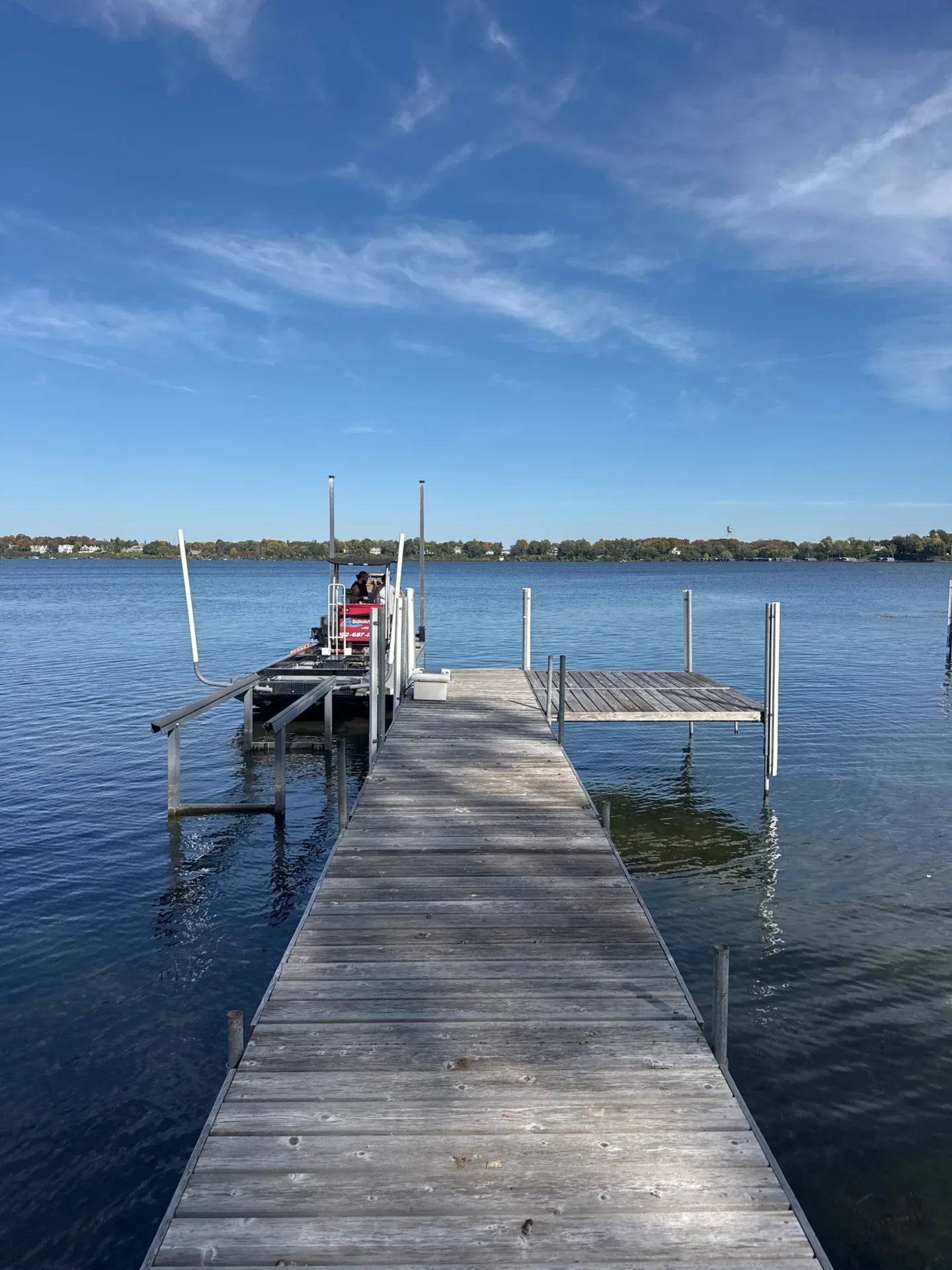 Wood-decked dock running out to a boat lift on Lake Minnetonka at Excelsior, before fall dock removal by BigWave Lake Service