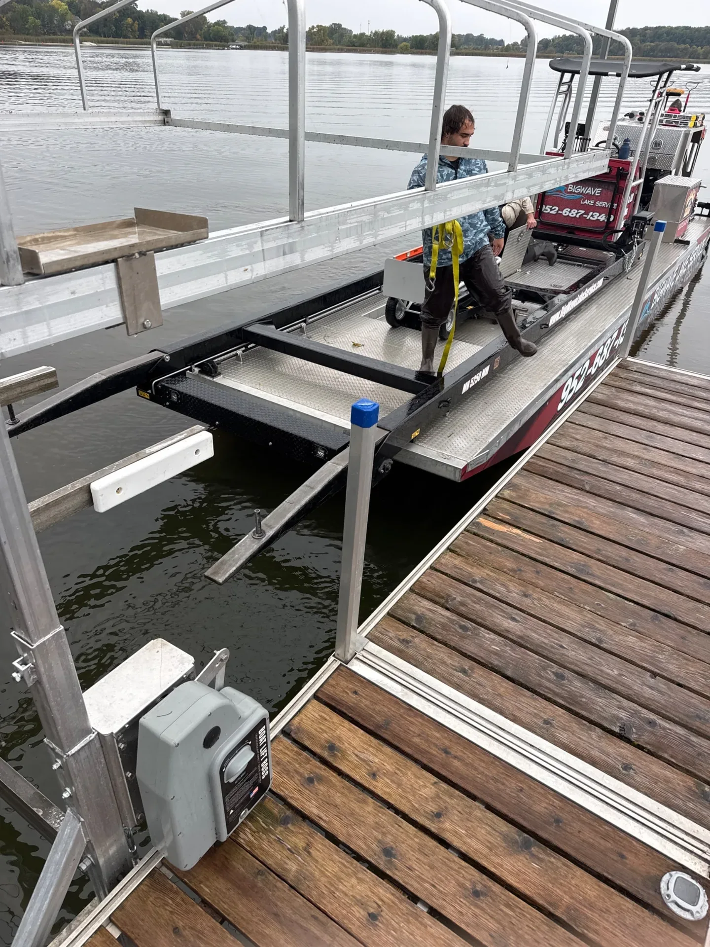 BigWave Lake Service barge pulled up beside a boat lift and dock on Spring Lake in Jordan during a Beach King lift removal, fall 2026
